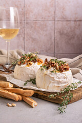 Brie or camembert cheese with thyme, nuts, honey, grissini and glass of white wine