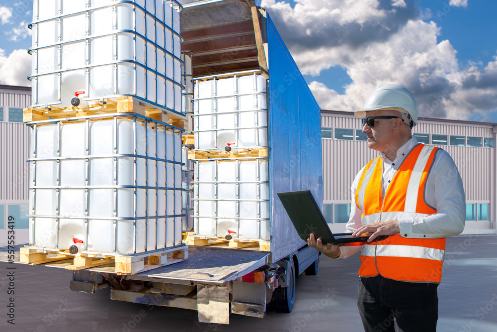 Poster man logistician near truck. worker controls unloading car. logistic warehouse worker with laptop. pa