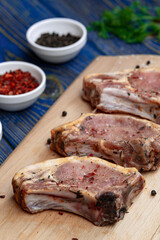 Fresh pork with ingredients for cooking on blue background