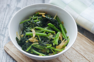 Top view of bowl with cooked spinach on table 