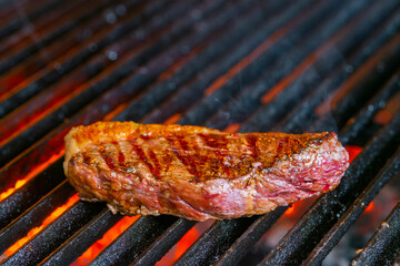 grilling steaks on flaming grill and shot with selective focus