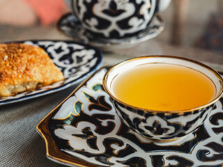Fresh, hot bun and a cup of fragrant tea. Sunny, clear day. Close-up, outdoors, no people. Tasty and healthy food concept