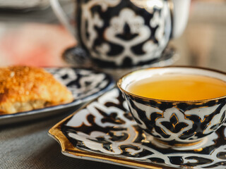 Fresh, hot bun and a cup of fragrant tea. Sunny, clear day. Close-up, outdoors, no people. Tasty and healthy food concept