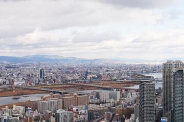 Obraz premium Overhead view of Osaka's Umeda area from a hill on a cloudy day