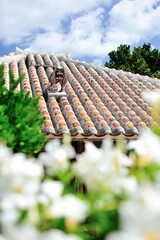 沖縄県竹富島　シーサーと赤瓦とテッポウユリ © 雅文 竹澤