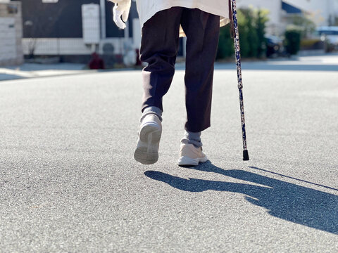 住宅地を杖をついて歩く高齢者の足元