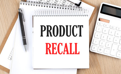 PRODUCT RECALL is written in white notepad near a calculator, clipboard and pen. Business concept