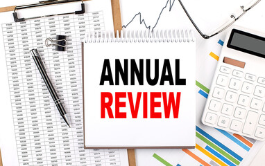 ANNUAL REVIEW text on notebook with chart, calculator and pen
