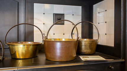 A set of copper cookware in a large kitchen