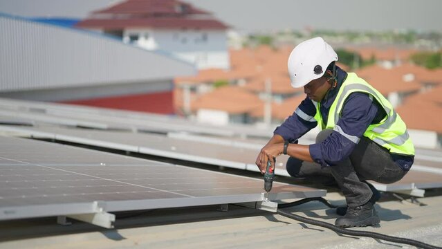 Engineer on rooftop sitting next to solar panels photo voltaic check alignment for good installation
