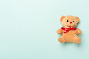 Cute teddy bear on color background, top view