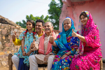 Happy Indian rural family setting at home and showing thumps up