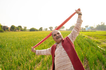 Indian farmer giving expression at agriculture field.
