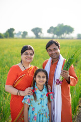 Indian farmer with wife and daughter at agriculture field.