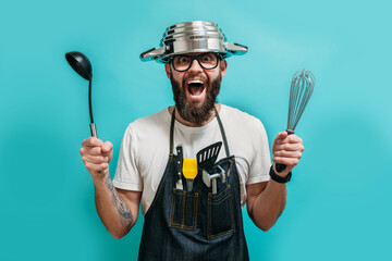 Funny bearded crazy chef with a pan on his head. Cooking. Crazy emotions