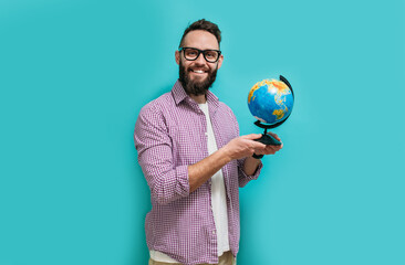 Smiling hipster man holding a globe in his hands. The concept of travel, vacation, see the world.