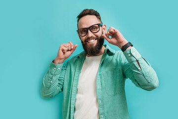 Cute hipster guy brushing his teeth with dental floss