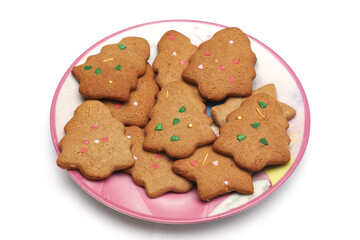 Homemade cookies in the form of a Christmas tree and a star in a plate on a white background. Close-up