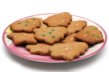 Homemade cookies in the form of a Christmas tree and a star in a plate on a white background. Close-up