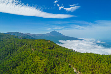 Aerial photo of mount Teide in the distance above the clouds. Volcano in Teide national park in Tenerife island, Spain.