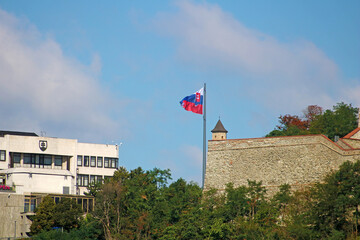Bratislava, Slovakia - September 03, 2019: Slovak National Parliament (left)  and slovak flag, part...