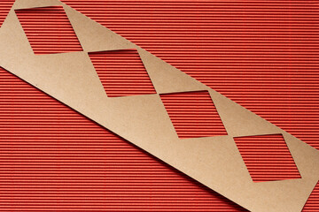 brown paper stencil with diamond shape cutouts on corrugated paper