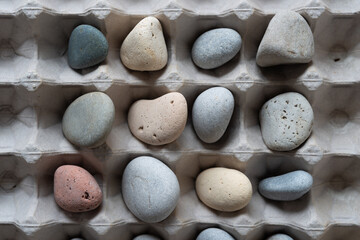 collection of neutral beach pebbles and egg cardboard box