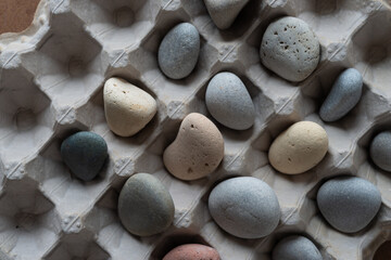 Fototapeta na wymiar beach stones or pebbles inside an egg carton