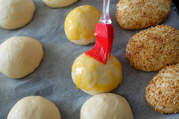 Brushing egg on raw cake dough, applying egg yolk on raw dough,