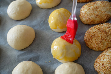 Brushing egg on raw cake dough, applying egg yolk on raw dough,