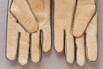 Fototapeta premium pig skin gloves in cork coloration on plain brown cardboard (palm side)