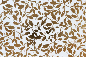 holiday themed scrapbook paper background: gold foil pattern holly leaves and berries on white © eugen