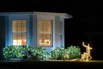 Brightly illuminated christmas decorations on front yard of florida family home. Outside decor for...