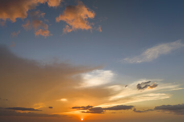 Colorful evening landscape with soft pastel coloured clouds on watercolor tinted sunset sky. Abstract nature background