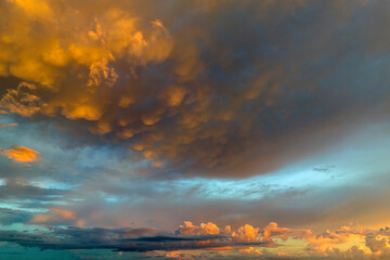 Obraz premium Cumulonimbus clouds forming before thunderstorm on evening sky. Changing stormy cloudscape weather at sunset