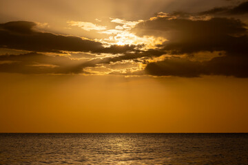 Fototapeta premium Dramatic red ocean waves at sunset with soft evening sea dark water