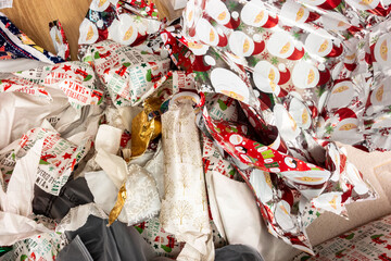 Piles of discarded Christmas wrapping paper left on the floor after presents have been opened.