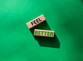 Feel better symbol. Wooden blocks with words Feel better. Beautiful green background. Business and Feel better concept. Copy space.