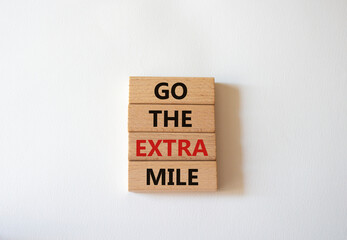 Go the extra mile symbol. Wooden blocks with words Go the extra mile. Beautiful white background. Business and Go the extra mile concept. Copy space.