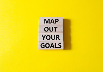 Goals symbol. Wooden blocks with words Map out your goals. Beautiful yellow background. Business and 'Map out your goals' concept. Copy space.