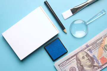 A flatlay picture of fingerprint pad on fake cash, copyspace notepad, pencil magnifying glass,...