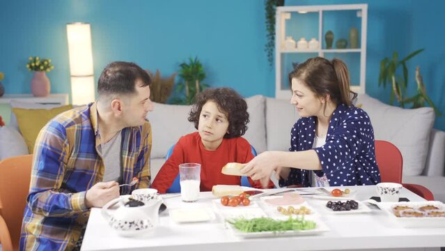Mom and boy are making fun of their father and having fun.
Happy and cheerful family making each other laugh and having fun at breakfast.
