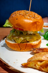 Organic vegetarian burger with plant based corn chicken burger, vegan cheese, green lettuce and baked potatoes
