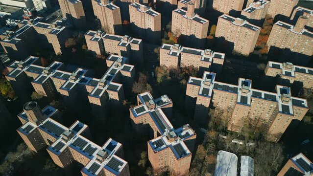 High angle view of multistorey brick buildings in residential urban borough. Producing green energy by rooftop solar cells. New York City, USA