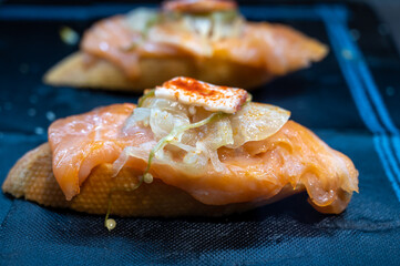 Typical snack of Basque Country, pinchos or pinxtos, small piece of bread with fish, jamon and different toppings, served in bar in San-Sebastian or Bilbao, Spain