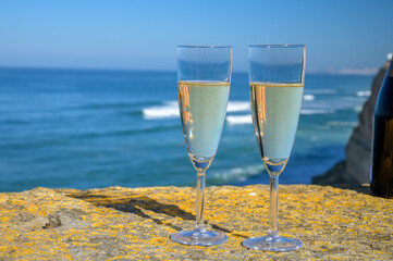 Glasses of champagne sparkling wine and view on blue Atlantic ocean, Lisbon area, Portugal