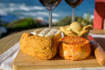 Food and wine pairing, red dry Portuguese wine, fish pastry, pie, variety of goat, sheep, cow cheeses made with paprika, herbs in Portugal