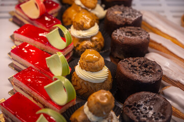Assortment of french fresh baked sweet pastry with fresh fruits and berries in confectionery shop