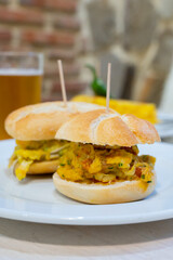 Typical mini burger snack of Basque Country, pinchos or pinxtos, small piece of bread with different toppings, served in bar in San-Sebastian or Bilbao, Spain