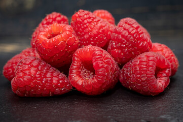 Fresh organic fruit - ripe red sweet raspberry on dark background